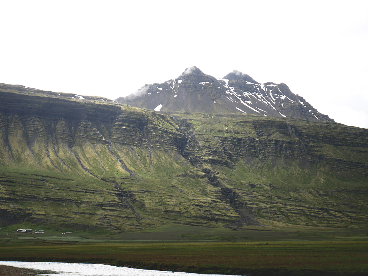 Riesiege Bergfront mit verschneiten Gipfeln im Hintergrund